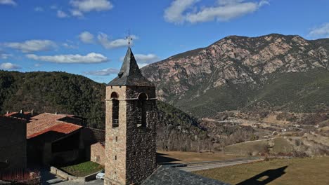 orbital-aerial-drone-view-over-a-bell-tower-in-Arséguel,-Catalan-Pyrenees