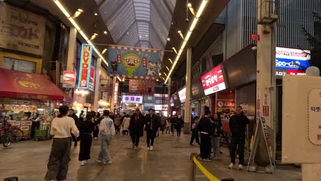 pedestrians walking through a lively covered shopping arcade