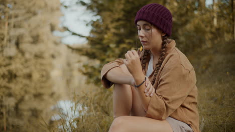 female explorer sitting with flower in forest