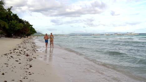 una mujer con un hombre involucrado en correr junto al mar
