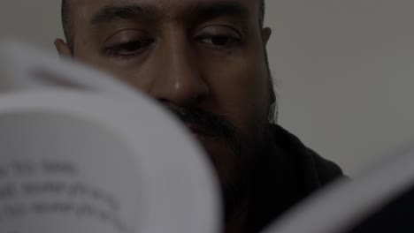 reino unido macho asiático adulto hojeando las páginas del libro