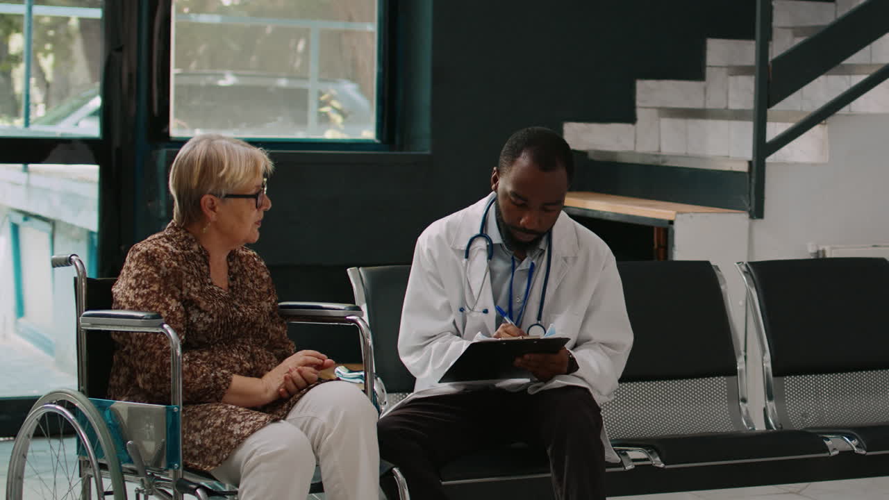 African american doctor consulting old woman in wheelchair