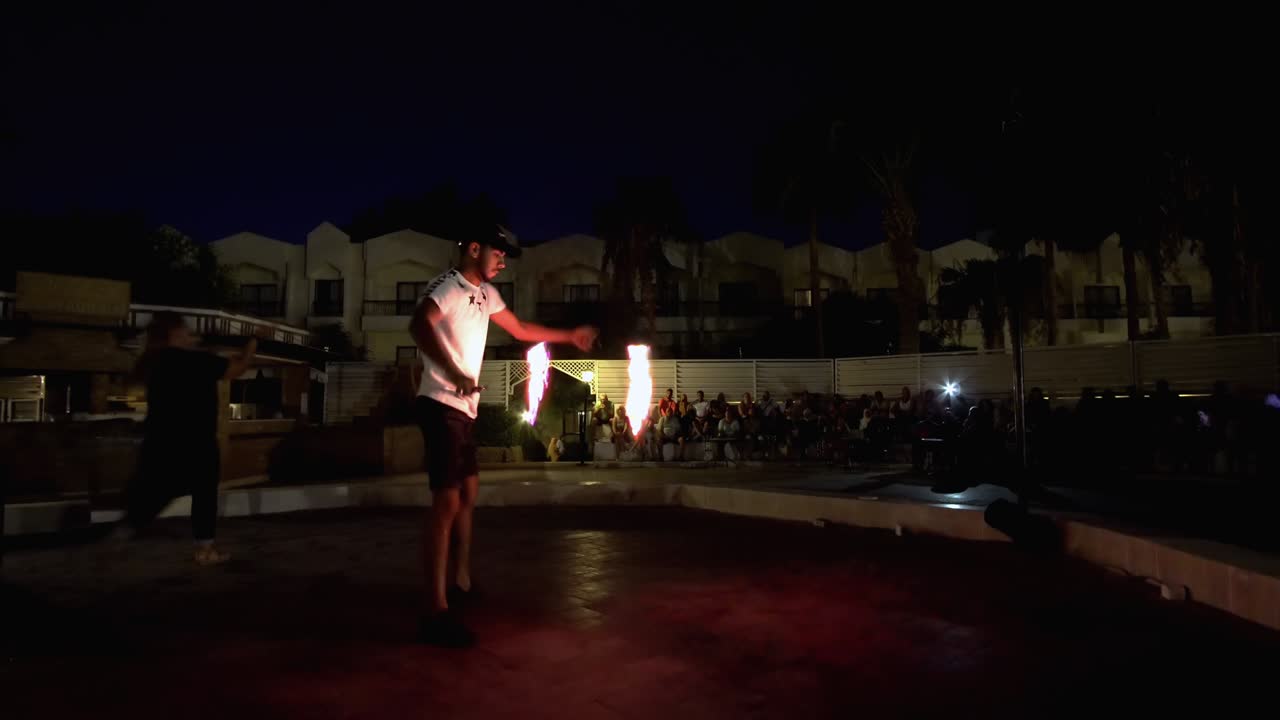 Poi dancer performing fire dance in the night