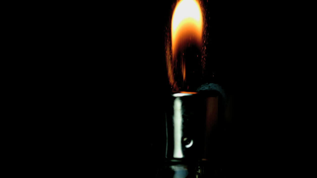 usando un encendedor a mano sobre un fondo negro