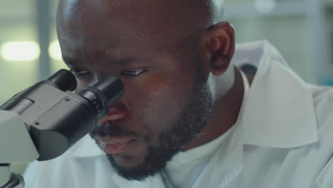 African American Lab Worker Using Microscope