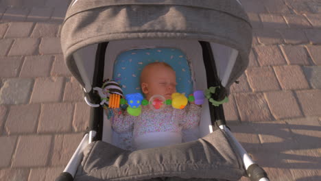 baby girl sleeping during outdoor walk in pram