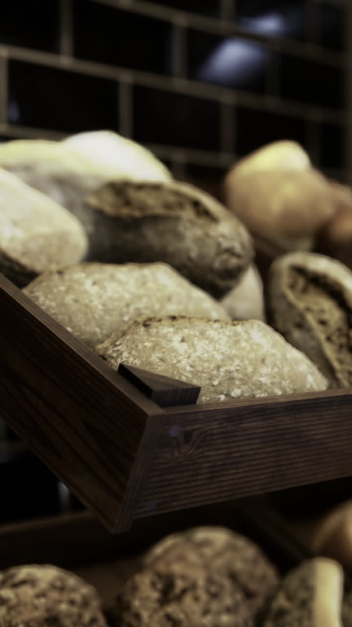 Variety of artisanal breads displayed on wooden shelves in a bakery
