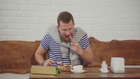 man eating breakfast in a cafe