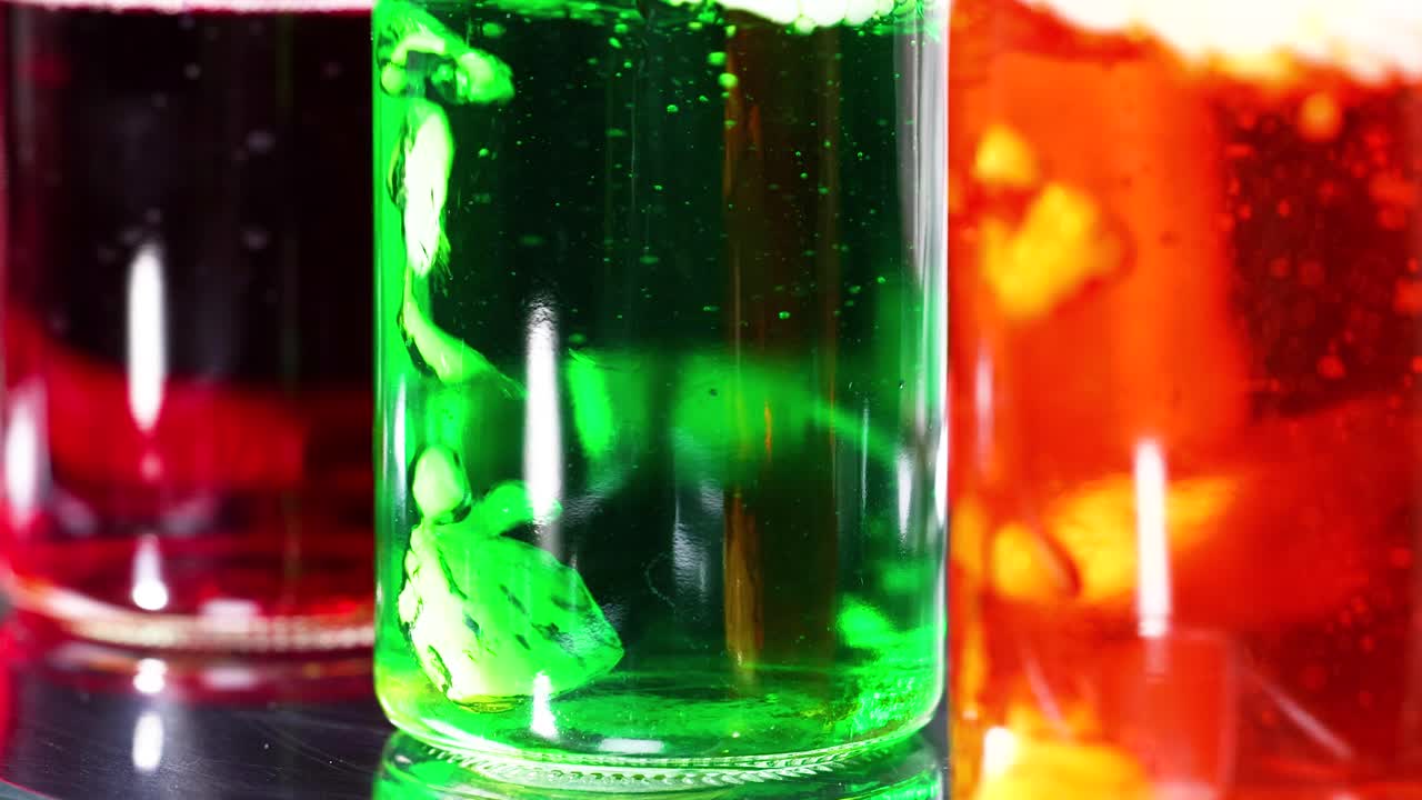 hielo seco reaccionando en vasos líquidos de colores