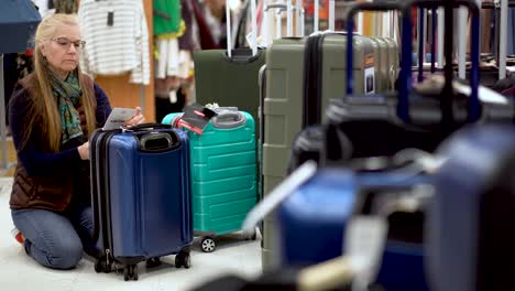 Woman-looking-at-luggage-in-a-hypermarket