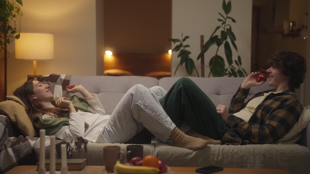 Couple Relaxing on Couch Tossing Fruit