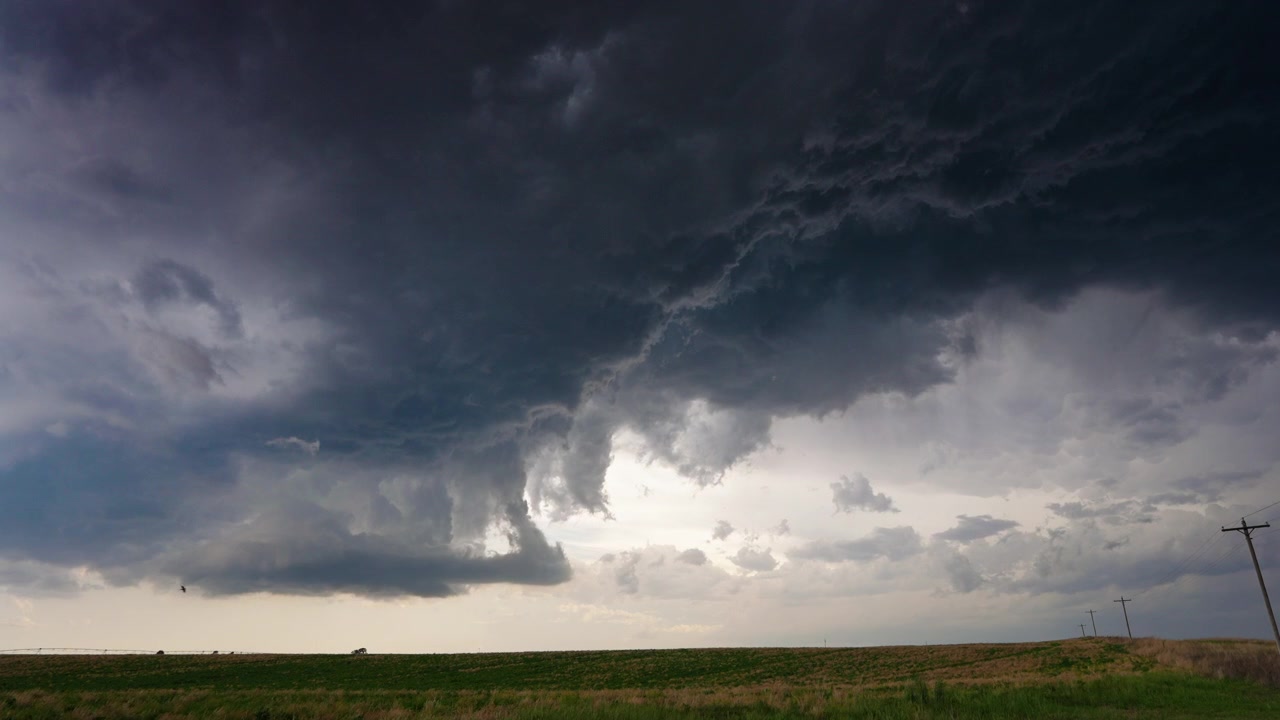 Spinning supercell thunderstorm building into the atmosphere overhead