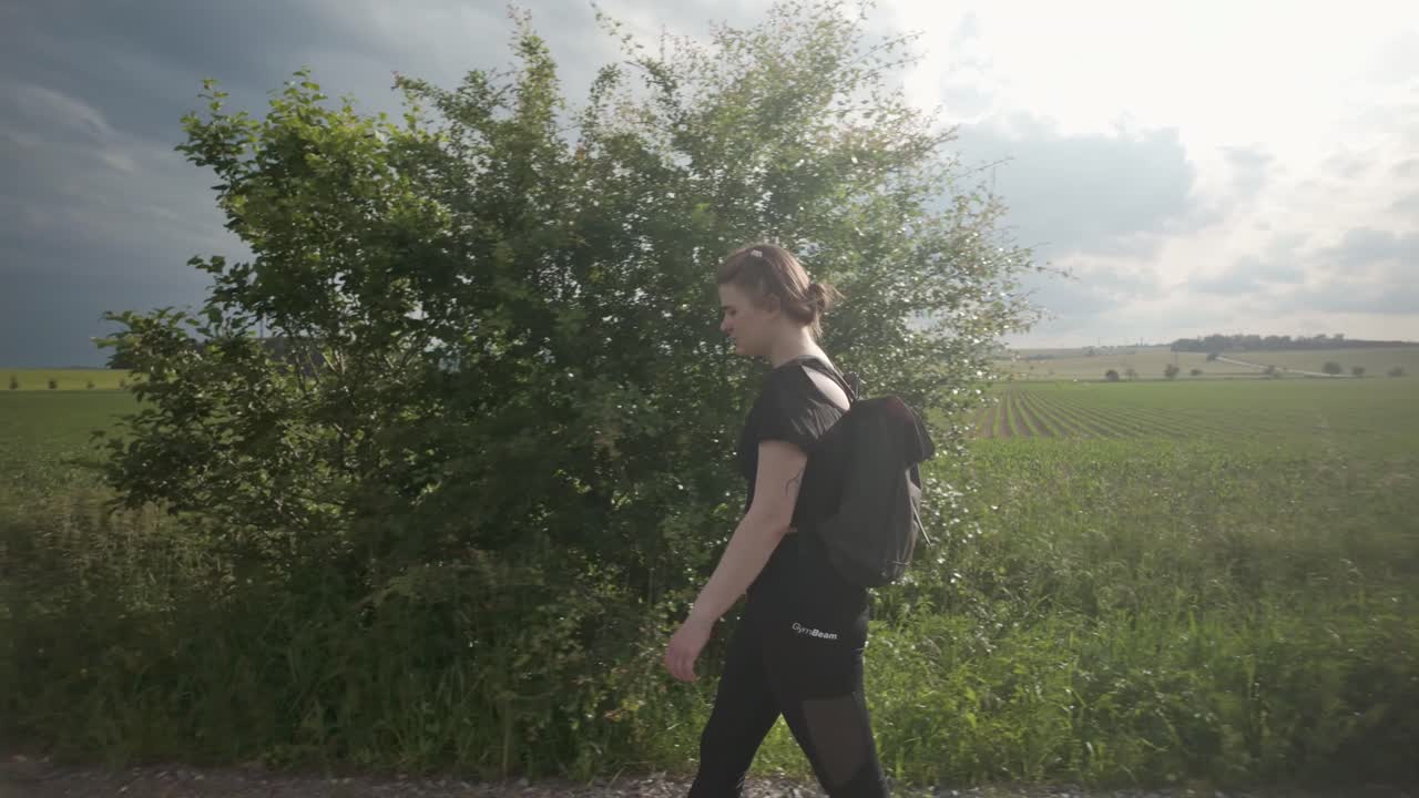 배을 들고 있는 소녀가 빛이 넘치는 을 혼자 걸어다니며 여행의 건강한 혜택과 평온한 자연 풍경을 즐기고 있다.