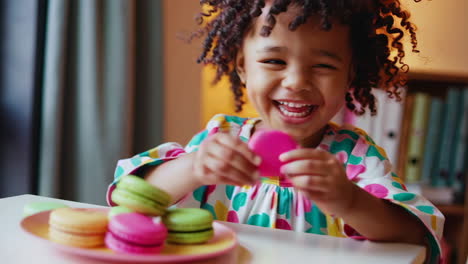 happy little girl joyfully eating a macaron