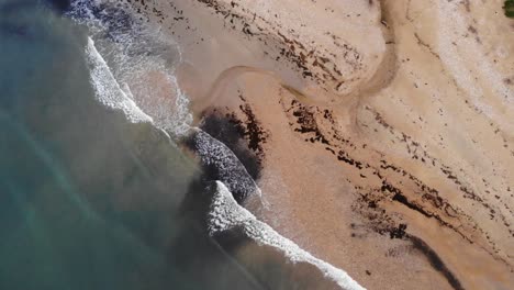 aerial top down view of waves breaking on charmouth beach in dorset