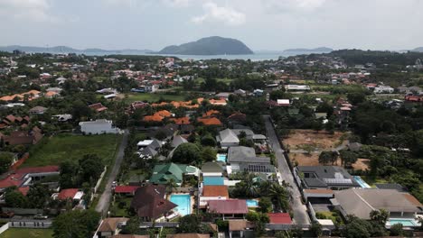aerial drone shot over phuket’s countryside and villages, showcasing lush greenery, tropical rooftops, and winding roads. a peaceful view of rural thailand and island life. traveling the world. fun