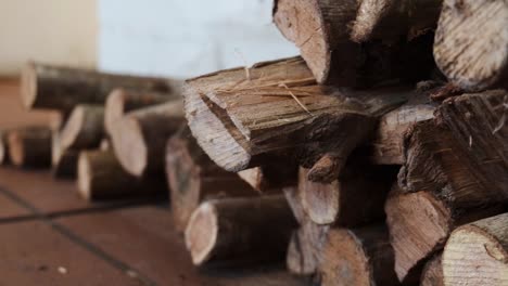 closeup firewood logs stacked timber woodpile on brown tiles floor pull back