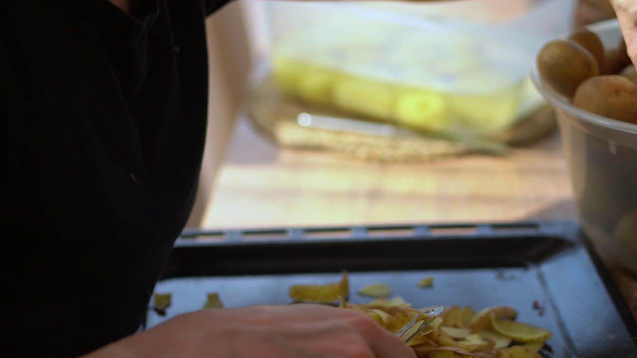 mujer pelando papas crudas usando un pelador de vegetales inoxidable