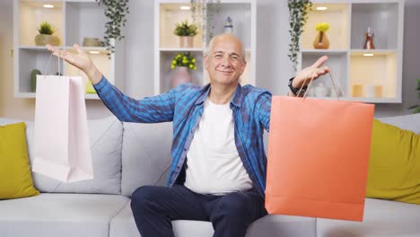 un anciano mostrando bolsas de compras a la cámara.