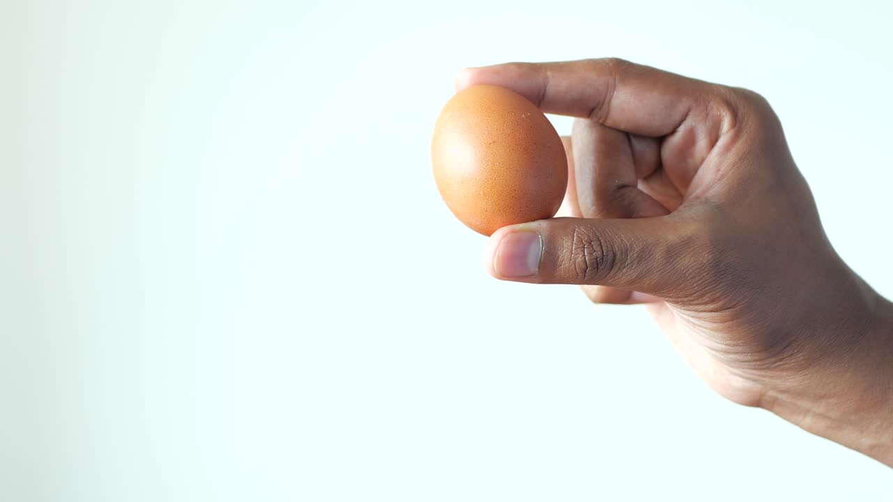 Men holding a egg against white background