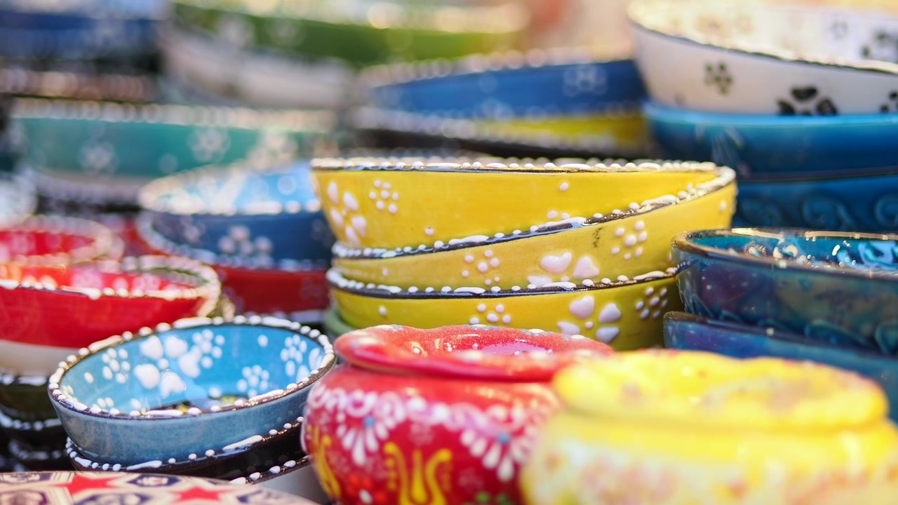 Ciotole in ceramica colorate e dipinte a mano esposte in un mercato
