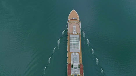 Ascending-top-down-shot-of-cruising-Cruise-Ship-on-beautiful-Ocean-during-daytime