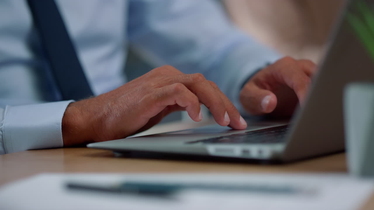 Businessman hands using touchpad on laptop. Fingers moving across touchpad area