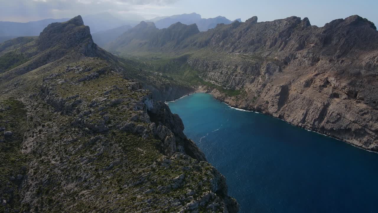 Experience breathtaking aerial views of the rugged coastline at Cap Formentor in Mallorca. The stunning landscape features the tranquil blue waters and dramatic cliffs of Tramuntana.
