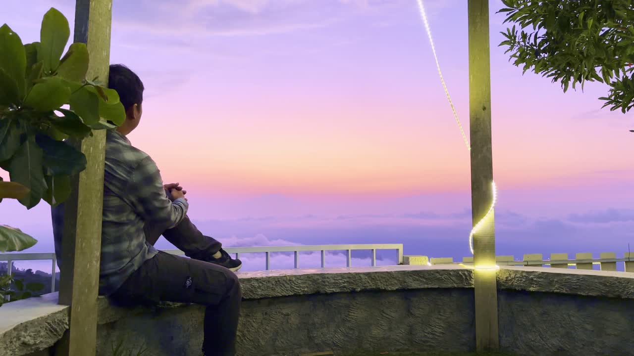 Man Contemplating Sunset Over Mountains