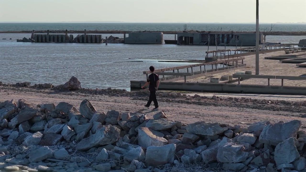 Luftbåren dronefølgning af en ung mand, der går gennem ruinerne af Villa Epecuen, Argentina.
