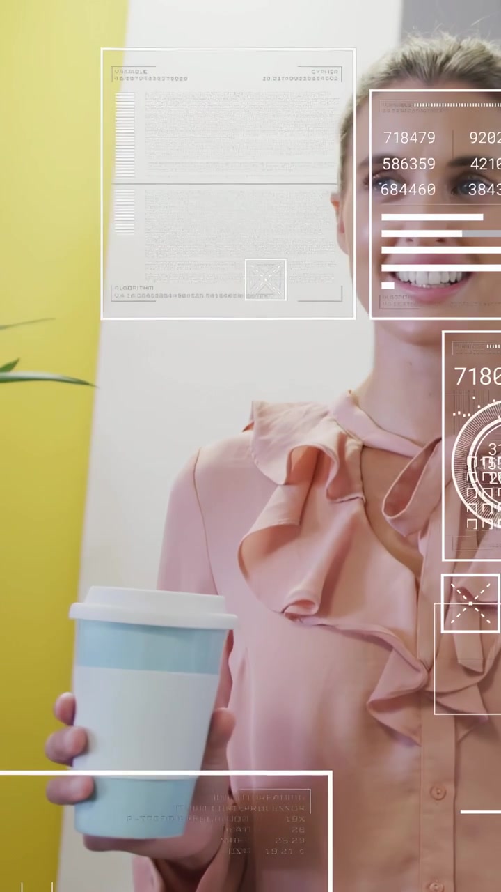 Vertical video: Woman turning and speaking in hallway holding cup HUD sliding tagging cup for tech