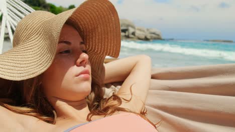 Front-view-of-Caucasian-woman-relaxing-in-a-hammock-at-beach-4k