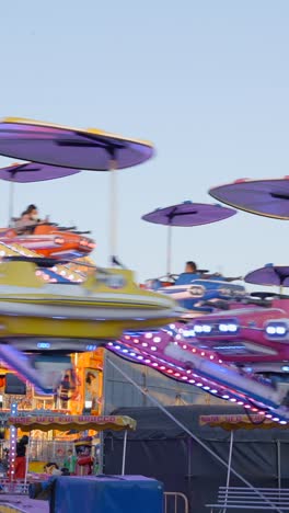 people enjoying a spinning amusement park ride at a fair