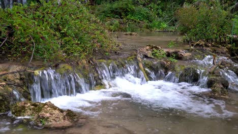 agua que fluye de un estanque a otro con coloridos arbustos verdes en el parque nacional krka en croacia