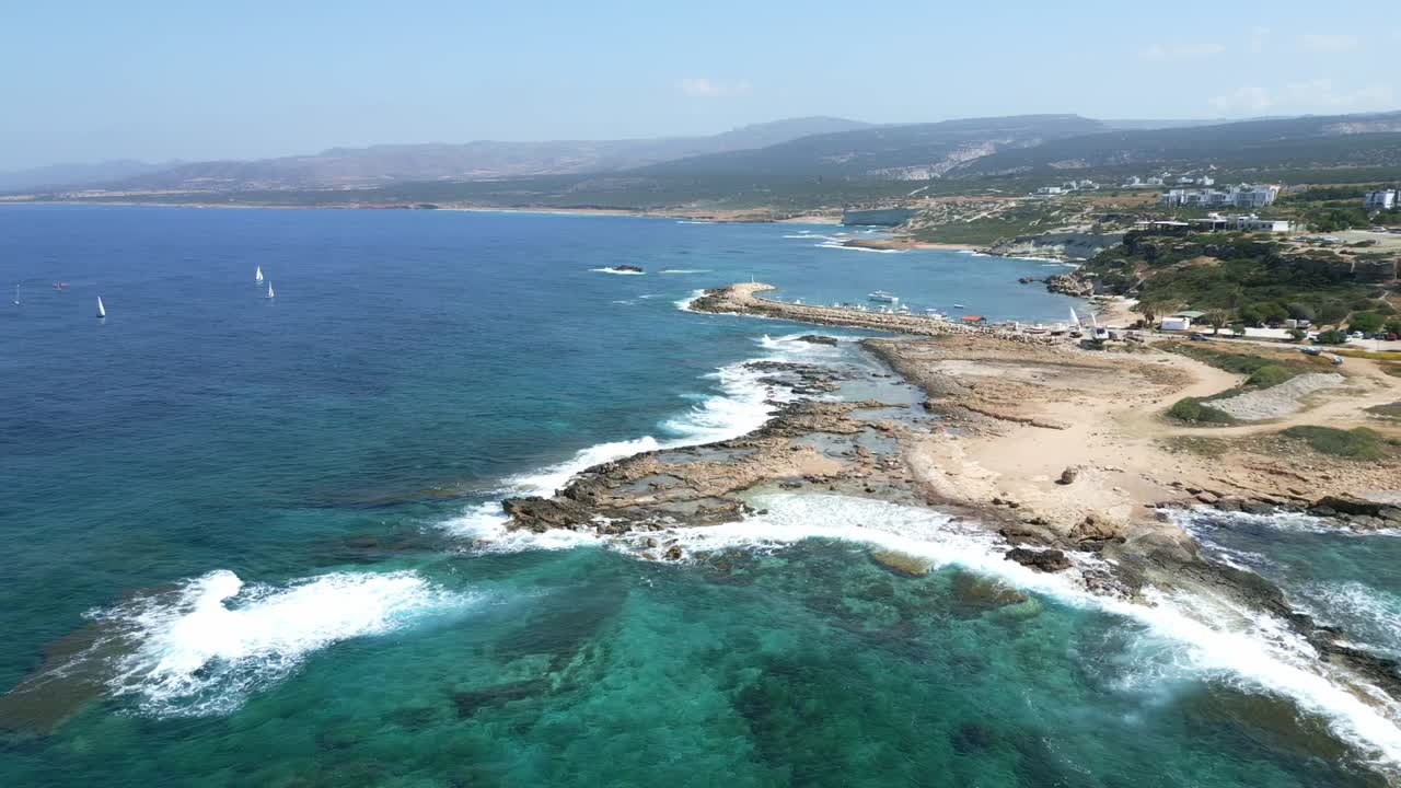 la playa de agios georgios en chipre con aguas azules claras y windsurfistas, vista aérea