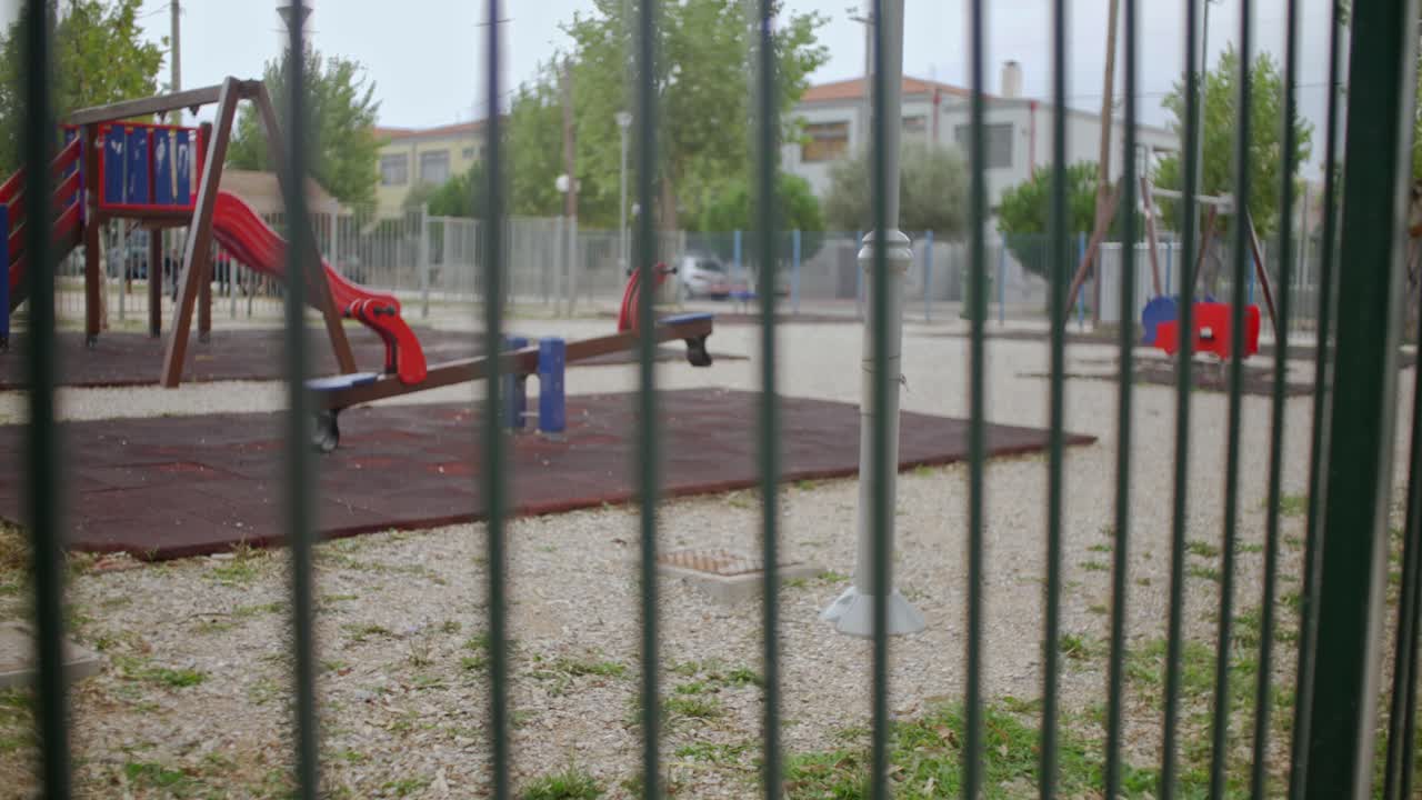 View of closed and sealed playground, during coronavirus lockdown, Pan shot, focus rack from railing to playground 4K