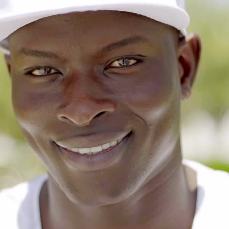 primer plano de un apuesto hombre negro sonriente con gorra