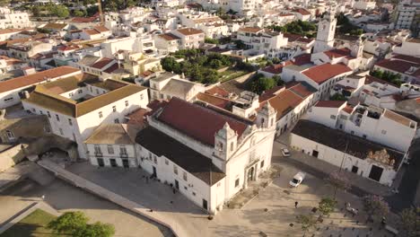 Luftaufnahme-Der-Igreja-De-Santo-António,-Einer-Reich-Verzierten-Kirche-Aus-Dem-18.-Jahrhundert,-Die-Gegenüber-Dem-Castelo-Dos-Governors,-Einem-Schloss-Mit-Barocker-Fassade-Und-Wachtürmen-In-Lagos,-Portugal,-Liegt