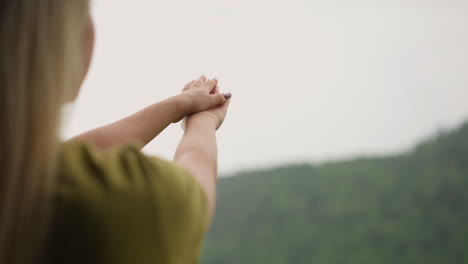 woman catches rain drops and spreads onto hands at resort