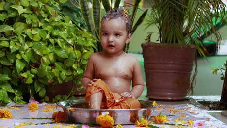 cute toddler baby boy bathing in decorated bathtub at outdoor from unique perspective