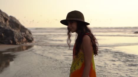 mujer joven admirando el mar al atardecer en cámara lenta