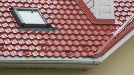 rainwater flows down the tiled roof into the drainpipe