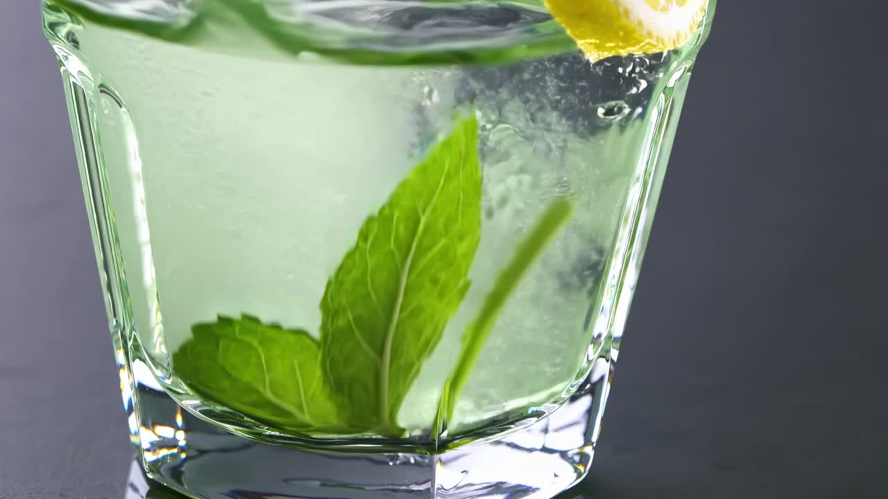 Refreshing cocktail in a glass with mint leaves and lemon slice, showcasing the vibrant colors and textures of the drink, capturing the essence of a perfect summer beverage experience