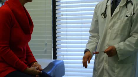 joven médico asiático examinando a un paciente anciano con martillo reflejo en la clínica 4k