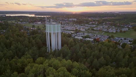 Aerial-long-shot-of-a-water-tower-and-residential-area-in-sunset