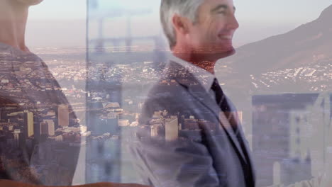 mid section of businessman and businesswoman shaking hands at office over aerial view of cityscape