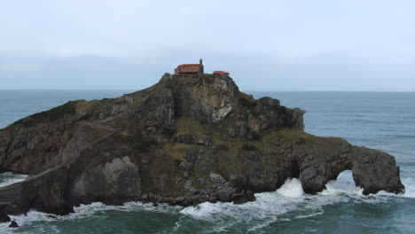 Aerial-orbit-shot-Gaztelugache-is-an-islet-in-the-Vizcaya-town-of-Bermeo,-Pais-Vasco,-Spain