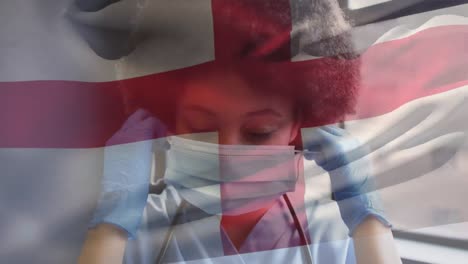 animation of flag of england and female doctor taking off mask and smiling