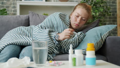 sick woman taking medicine at home