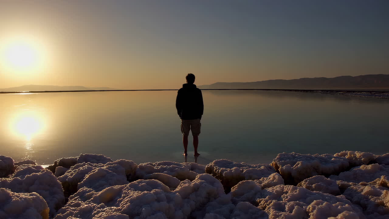 Man Standing on the Dead Sea Shore at Sunrise
